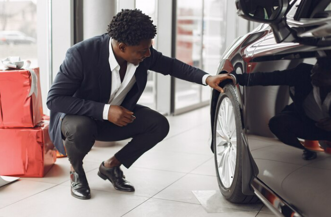 Young man check a car for dirts in a bid to charge avis cleaning fee