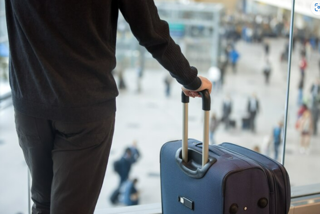 Man with his baggage collected from the baggage claim area