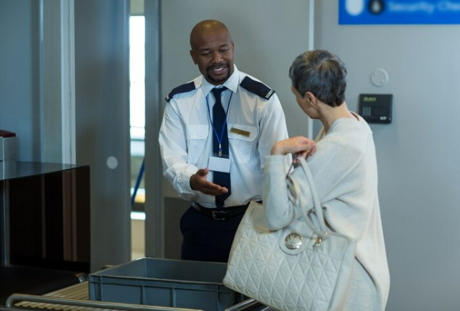 Airport Security officers holding woman for secondary inspection