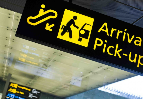 A shot of a signboard at the Airport arrival pickup zone signaling the location's name