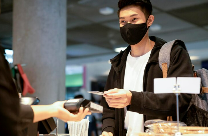 Asian Man paying parknig money when going to pick someone at the airport 